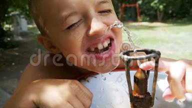 快乐的小男孩滑稽地从游乐场的饮水喷泉中喝水慢动作